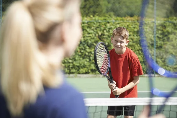 Тренер по теннису дарит урок мальчику — стоковое фото