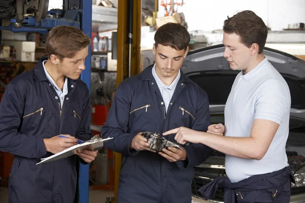 Mechaniker unterrichten Auszubildende in Werkstatt — Stockfoto