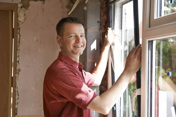 Construction Worker Installing New Windows In House Stock Picture