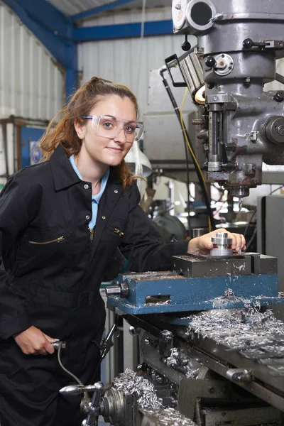 Vrouwelijke leerling ingenieur bezig met boor in fabriek — Stockfoto