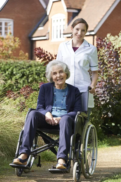 Portrait of Carer Pushing Senior Woman In Wheelchair — стоковое фото