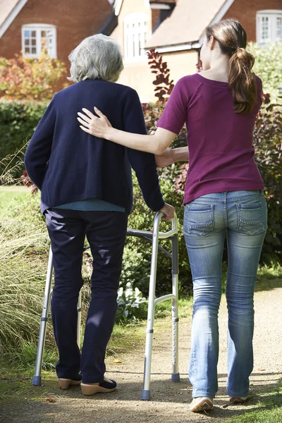 Hija ayudando a la madre mayor a usar el marco para caminar — Foto de Stock