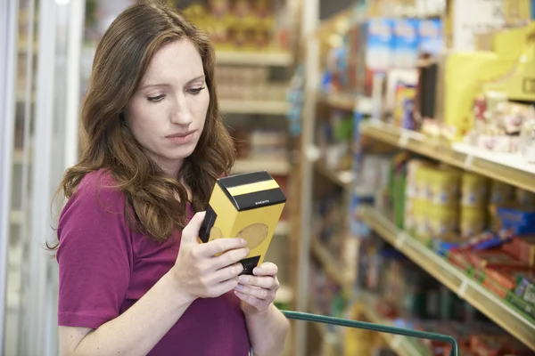 Γυναίκα έλεγχος σήμανσης στο κουτί σε σούπερ μάρκετ — Φωτογραφία Αρχείου