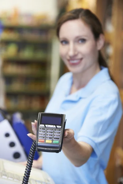 Mujer Asistente de ventas que sostiene la máquina de tarjeta de crédito — Foto de Stock