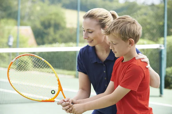 Kvinna Tennis tränare ger lektion till pojke — Stockfoto