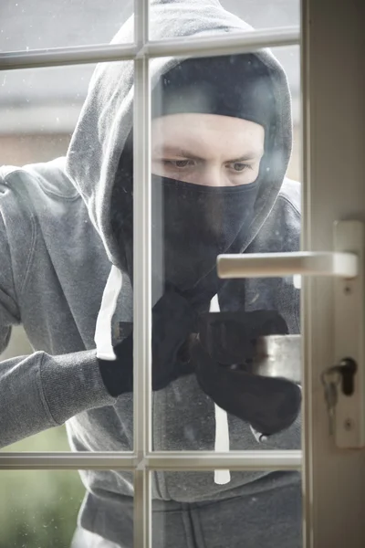 Ladrón irrumpiendo en la casa forzando la puerta con barra — Foto de Stock