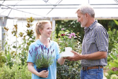 Male Customer Asking Staff For Plant Advice At Garden Center clipart