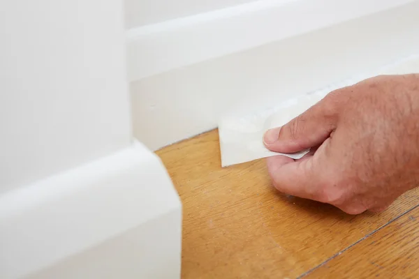 Close Up Of Man Removing Masking Tape From Skirting Board — Stock Photo, Image