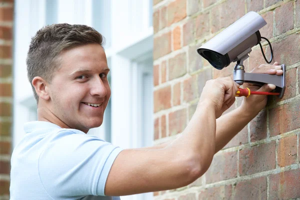 Sicherheitsberater montiert Überwachungskamera an Hauswand — Stockfoto