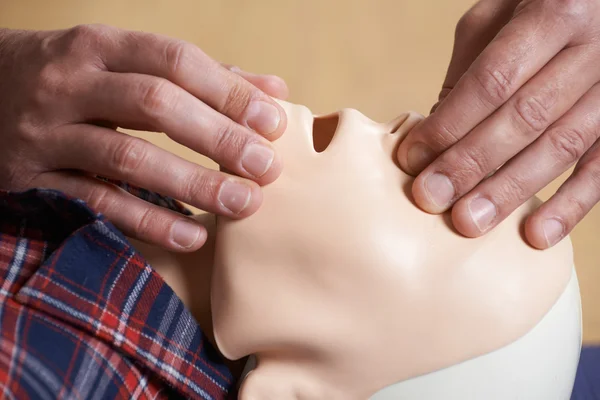 Человек в классе скорой помощи проверяет дыхательные пути на манекене — стоковое фото