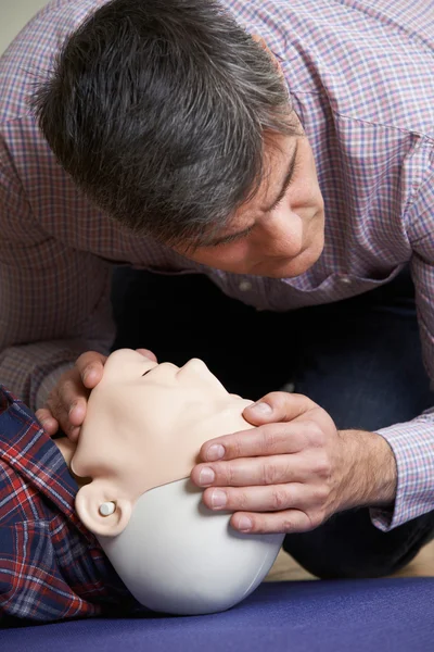 Hombre en primeros auxilios chequeando las vías respiratorias en el maniquí de RCP — Foto de Stock
