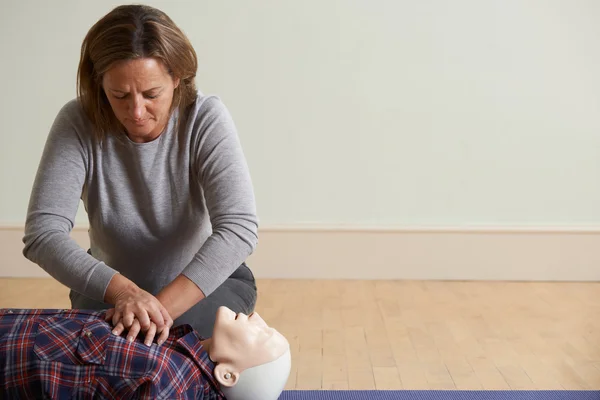 Frau im Erste-Hilfe-Kurs mit CPR-Technik an Attrappe — Stockfoto