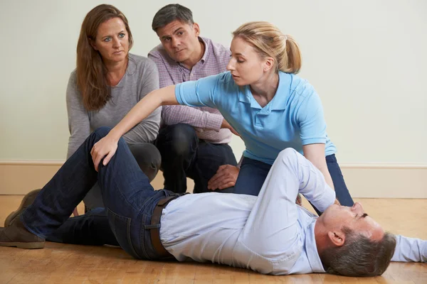 Frau demonstriert Erholungsposition bei Erste-Hilfe-Ausbildung — Stockfoto