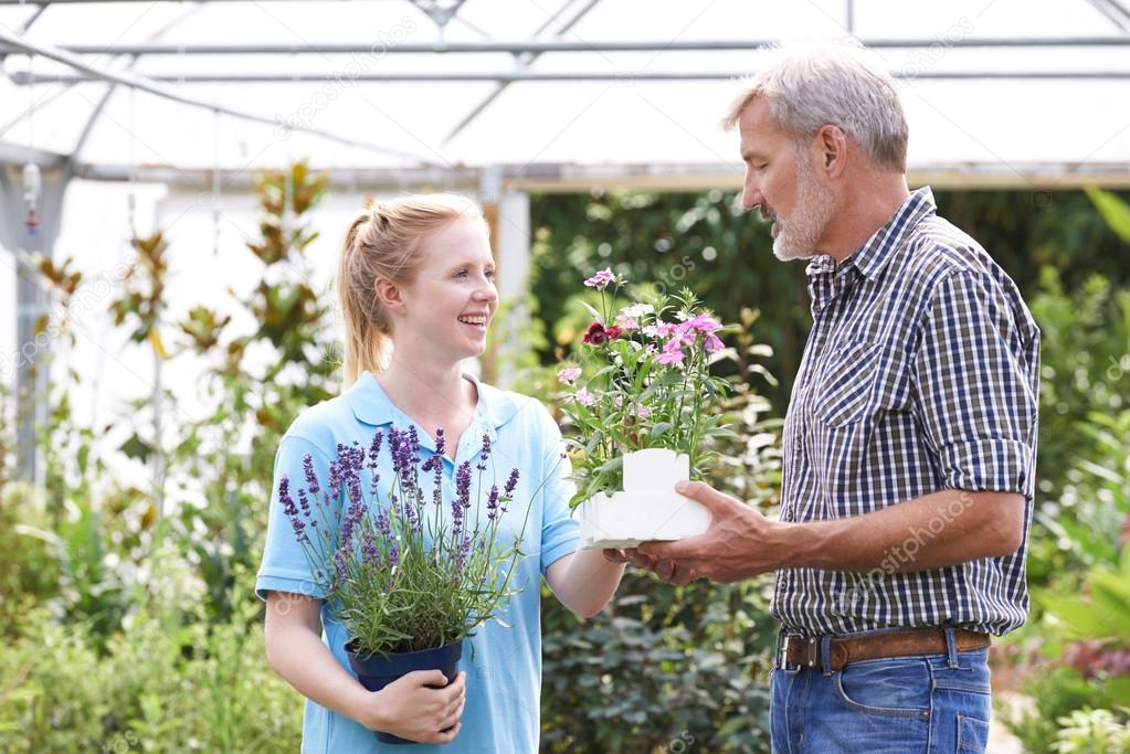 Male Customer Asking Staff For Plant Advice At Garden Center