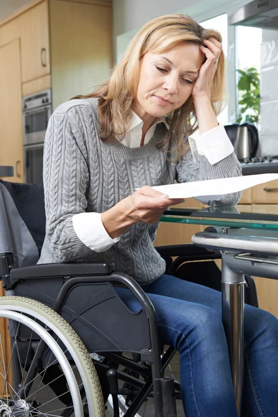 Frustrierte Frau im Rollstuhl liest Brief — Stockfoto