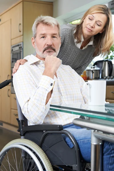 Kvinnan tröstande deprimerad Man i rullstol hemma — Stockfoto