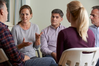 Members Of Support Group Sitting In Chairs Having Meeting clipart