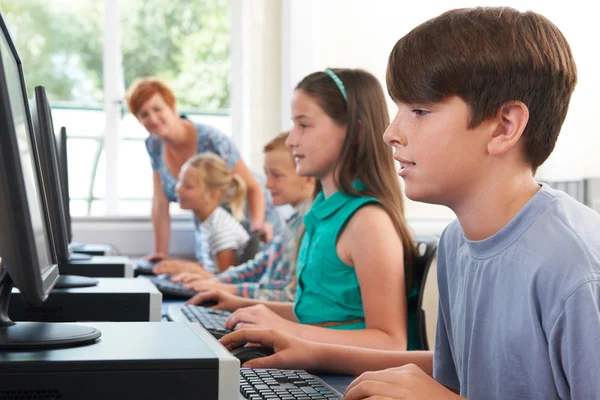 Groep van elementaire leerlingen in computer klas met leraar — Stockfoto