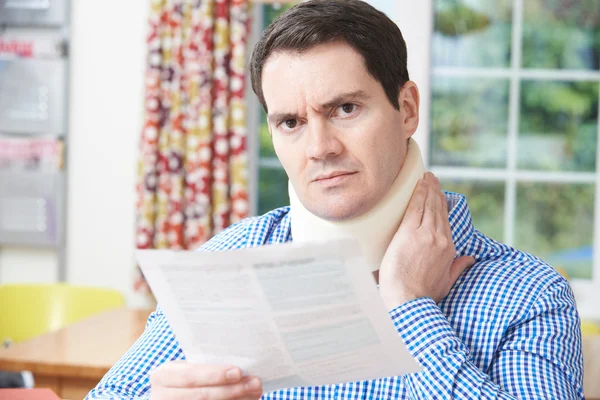 Homem leitura carta depois de receber lesão no pescoço — Fotografia de Stock