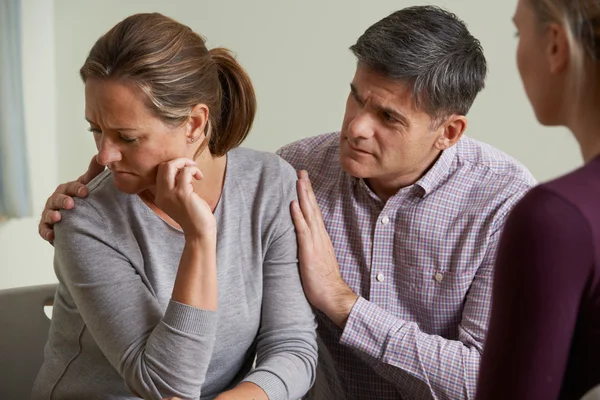 Älteres Paar spricht mit Berater, während Mann Frau tröstet — Stockfoto