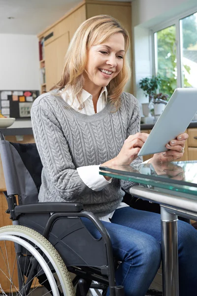 Behinderte Frau im Rollstuhl nutzt digitales Tablet zu Hause — Stockfoto