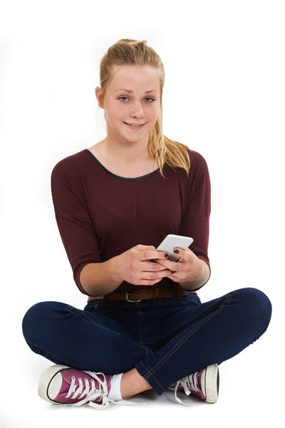Studioaufnahme von Teenager-Mädchen, das SMS verschickt — Stockfoto