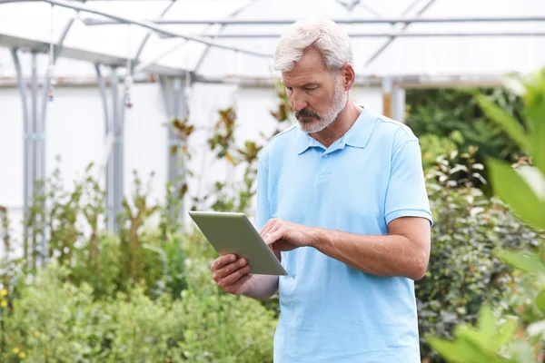 Asistent prodeje v zahradní centrum s digitálním tabletu — Stock fotografie