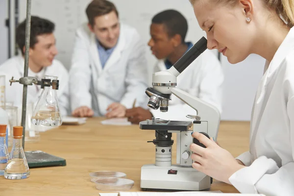 女学生在科学课中使用显微镜 — 图库照片