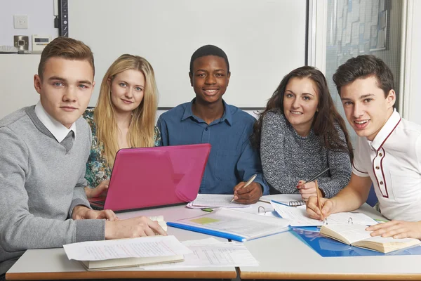 Grupp tonåriga elever arbetar tillsammans i klassrummet — Stockfoto