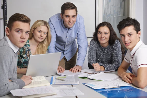 Retrato del maestro y los alumnos trabajando juntos en el aula — Foto de Stock