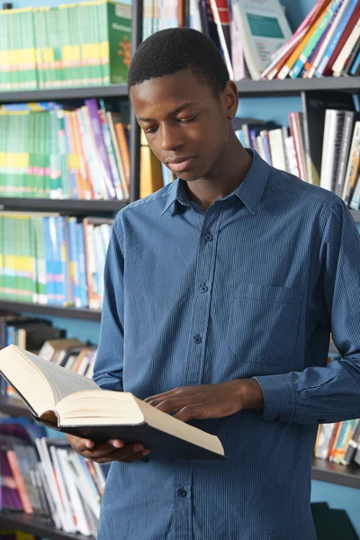 Homme adolescent étudiant lecture livre dans la bibliothèque — Photo