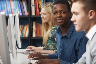 Genç öğrenci sınıfta bilgisayarlardaki çalışma grubu