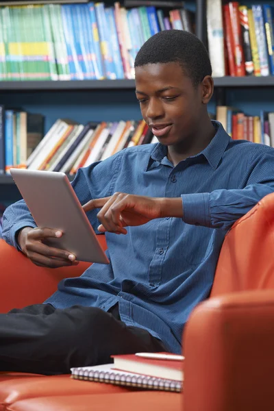 Mężczyzna nastoletnią Student za pomocą cyfrowego tabletu w bibliotece — Zdjęcie stockowe