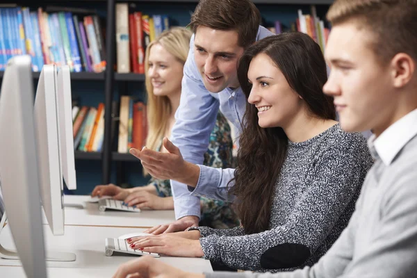 Tutor ajudando adolescentes estudantes que trabalham em computadores — Fotografia de Stock