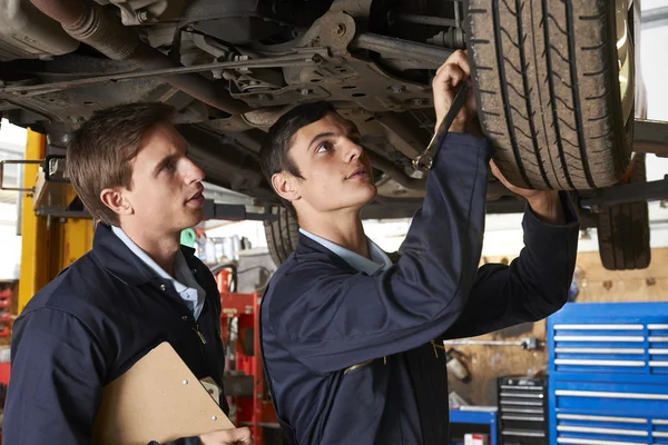 Mecánico y aprendiz trabajando juntos en el coche — Foto de Stock