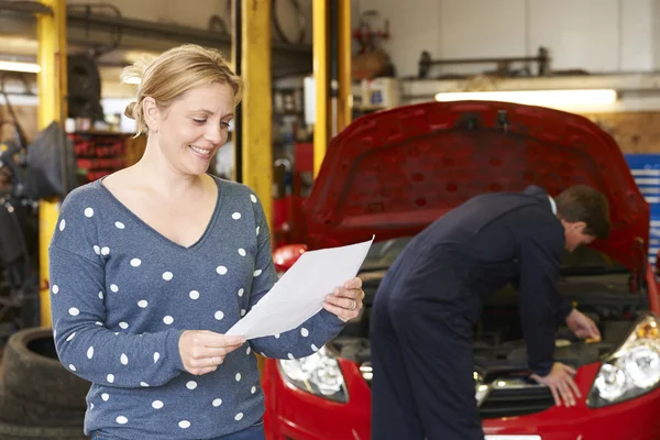 Femme heureuse avec projet de loi de réparation de garage — Photo