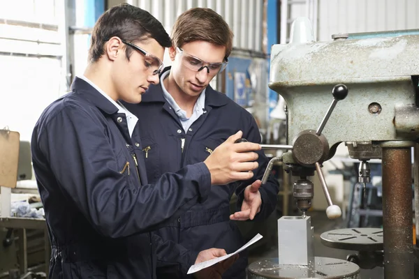 Ingenjör och praktikant med utrustning i fabrik — Stockfoto