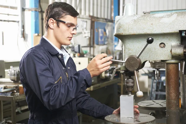 Teenage lärling verksamma Drill i fabrik — Stockfoto