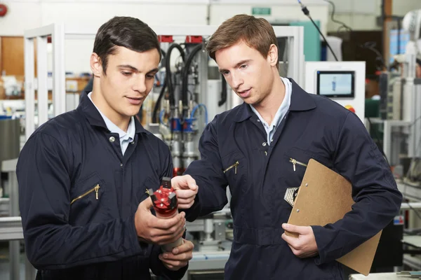 Engenheiro e estagiário discutindo componente na fábrica — Fotografia de Stock