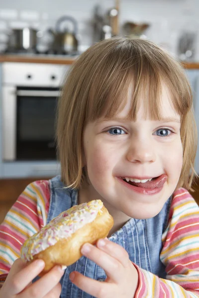 Joven chica disfrutando pegajoso donut —  Fotos de Stock