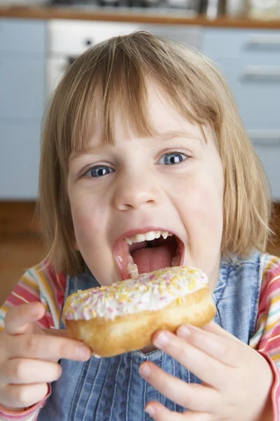 Nuori tyttö nauttii sokerinen donitsi — kuvapankkivalokuva