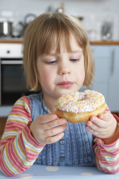 Joven chica disfrutando comiendo donut azucarado —  Fotos de Stock