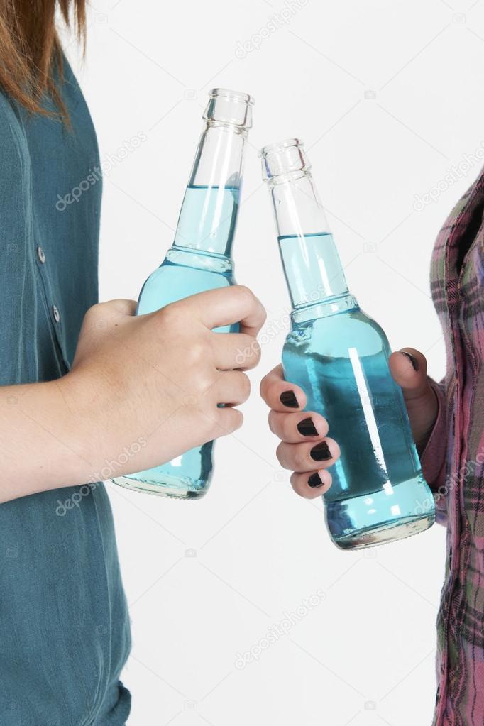 Studio Shot Of Two Teenage Girls Drinking Alcohol