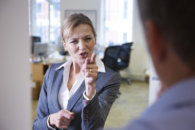 Aggressive Businesswoman Shouting At Male Colleague clipart