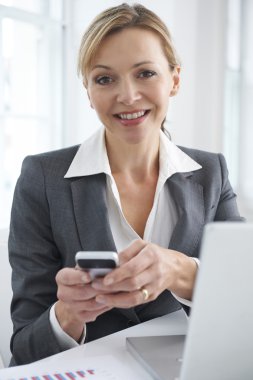 Portrait Of Businesswoman Texting On Mobile Phone clipart