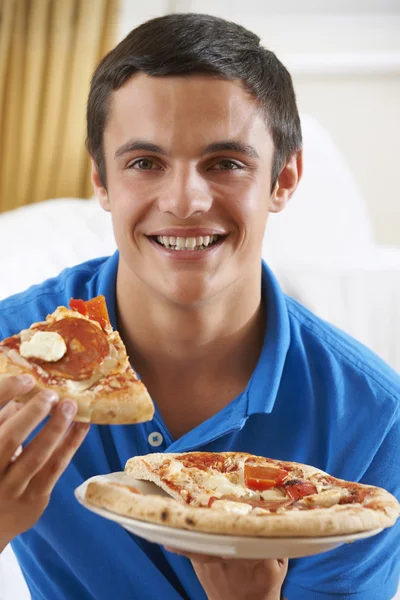 Adolescente ragazzo mangiare pizza a casa — Foto Stock