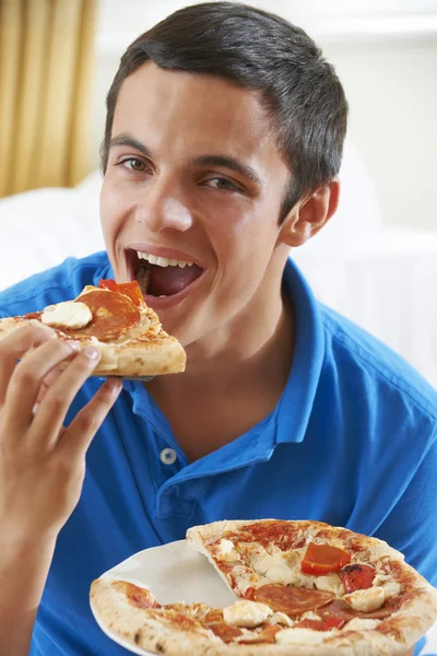 Nastoletni chłopiec jedzenie kawałek pizzy — Zdjęcie stockowe