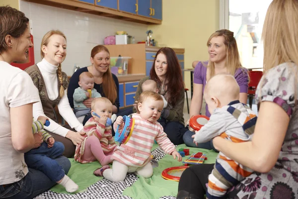 Grupo de madres con bebés en el grupo de juegos — Foto de Stock