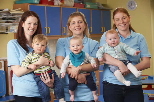 Groep van werknemers met baby's In kwekerij — Stockfoto