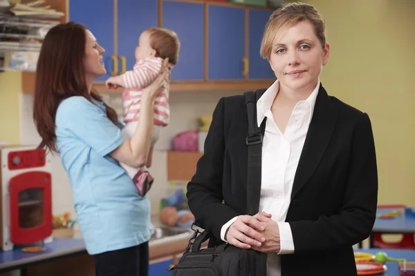 Arbetande mamma släppa barnet bort på plantskola — Stockfoto